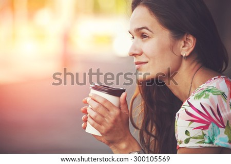 pretty girl sitting in street with morning coffee
