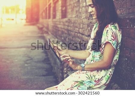 girl holding digital tablet pc at street in sunrise light