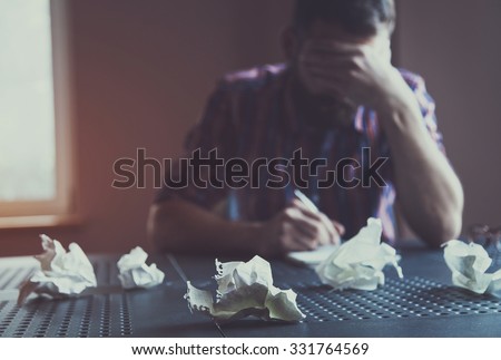 Paper balls during bearded man writing