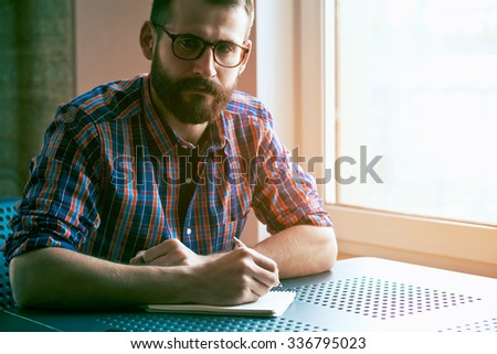 handsome bearded man with pen and notebook
