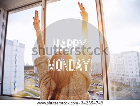 Woman facing the sunrise with raising hands. Happy Monday motivational text