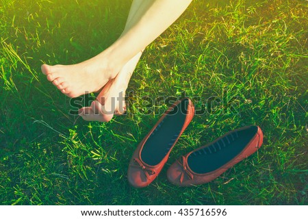 girls legs lying in grass barefoot without shoes
