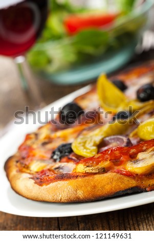 closeup of a pizza with red wine
