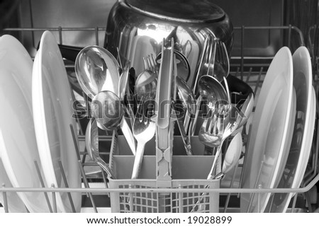 dinnerware and cutlery inside a dishwasher