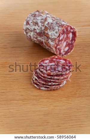 slices of an a italian salami on an oak table