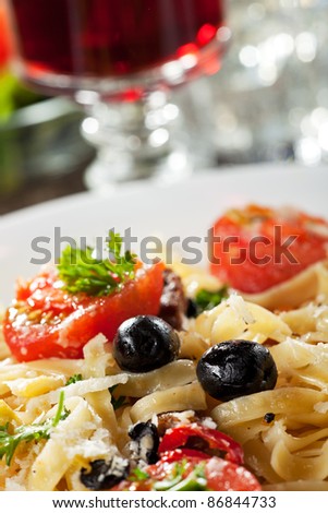 fresh pasta with tomatoes and olives on a plate