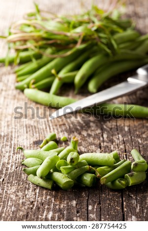 french beans and a knife on wood