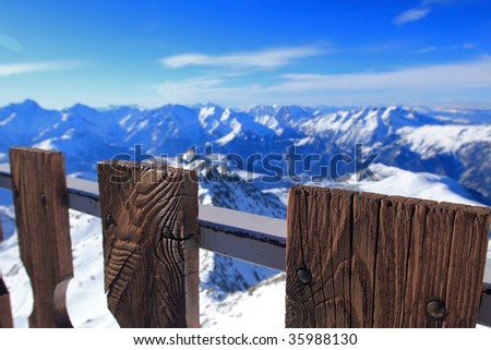 mountain landscape in the winter, mountains covered in snow, peaceful scenery in the mountains, snow covered landscape, mountain peaks viewed through a fence, snowy peaks