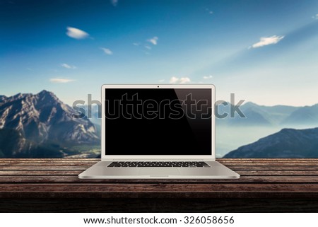 white laptop on the table with mountains in the background mock up presentation