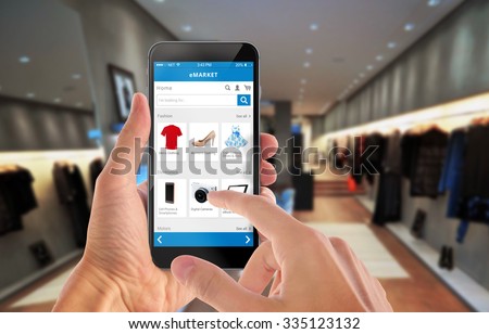 Smart phone online shopping in man hand. Shopping center in background. Buy clothes shoes accessories with e commerce web site