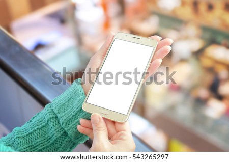 Woman showing gold smart phone with isolated, white, blank display for app promotion mockup. Coffee in background.