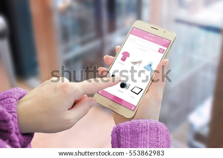 Online shopping with smart phone. Woman use shop web site to buy red shoes. Business center in background.