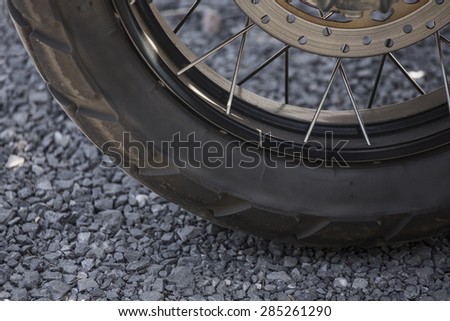 close up wheel of motorbike on small rock floor