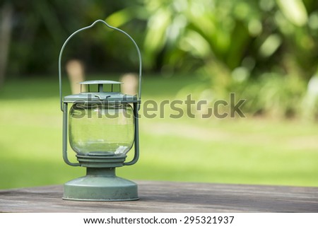 Lantern on wood table in a large forest
