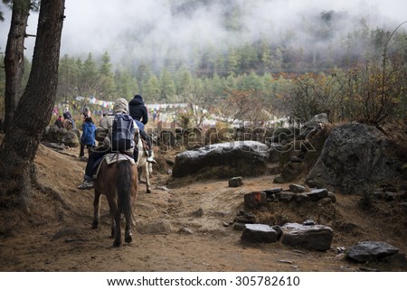 PARO - BHUTAN, DECEMBER 15 : People traveling to Taktshang Goemba by horse December 15, 2014