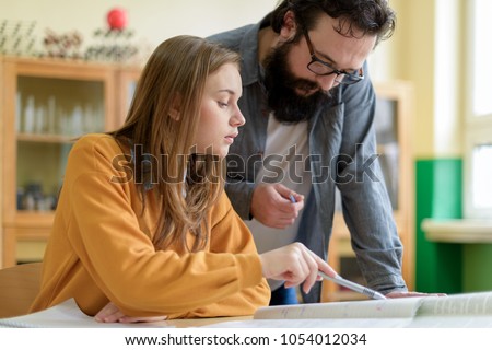 Young teacher helping his student in chemistry class. Education, Tutoring and Encouragement concept.
