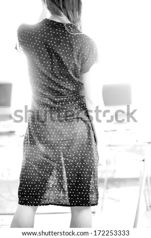 Vertical black & white image of sexy caucasian woman in a see through dress