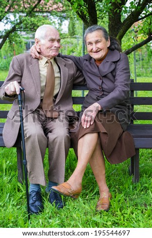 Cute 80 plus year old married couple posing for a portrait in their garden. Love forever concept.
