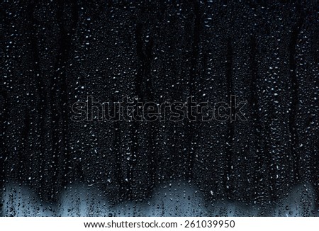 Rain droplets running down a window, abstract backlight background