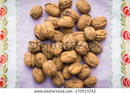 Pile of organic walnuts on vintage kitchen cloth, clean eating concept