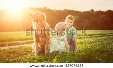Adorable brother and sister playing with pet dog