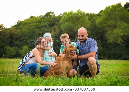 Beautiful young family with their pet dog, golden retriever