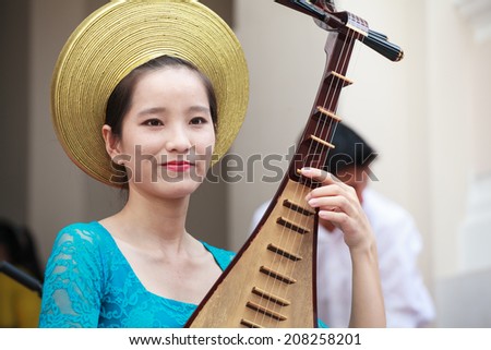 HO CHI MINH, VIETNAM- APIRL 23, 2014: Unidentified Vietnamese musicians performing music on Zither, traditional instrument at the Labor Cultural Palace on Apirl 23, 2014. in Saigon, Vietnam.