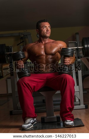 bodybuilder doing heavy weight exercise for biceps