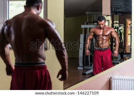 body builder posing at the mirror