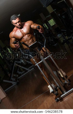 bodybuilder workout on the elliptical machine