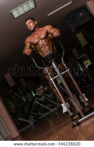 fit bodybuilder using the elliptical machine