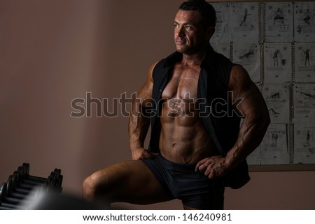 muscle bodybuilder posing in black shirt without sleeves