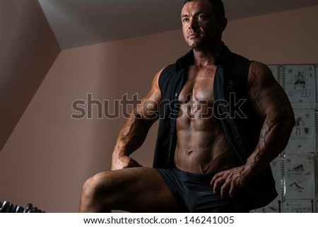 bodybuilder posing in black shirt without sleeves