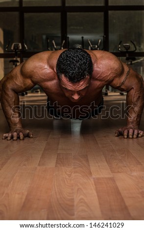 bodybuilder doing push ups at the floor