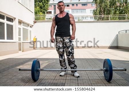 Man Resting After Doing Lunge with Barbells