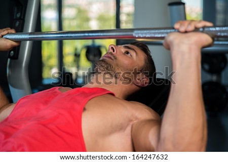 Bench Press At Gym. Young Men In Gym Exercising On The Bench Press