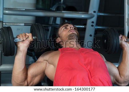 Workout Bench Dumbbell Training. Attractive Fit Men Lying On A Weight Bench Working Out With Dumbbell