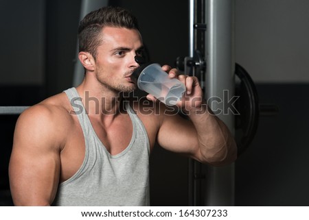 Man Drinking Water After Exercise. Healthy Young Man Resting And Drinking Water At Gym