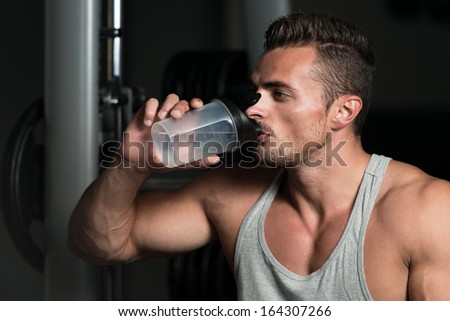Fit Man Drinking Water. Healthy Young Man Resting And Drinking Water At Gym