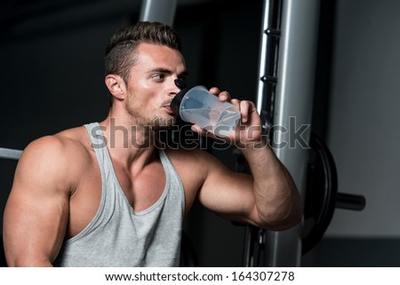 Drinking Water. Healthy Young Man Resting And Drinking Water At Gym
