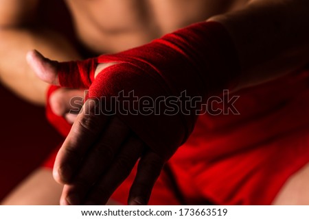 Fighter Putting Straps On His Hands - Muscled Boxer Wearing Red Strap On Wrist