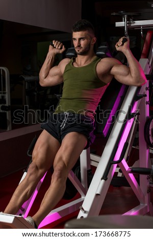 Fit Man Using The Leg Press Machine At A Health Club