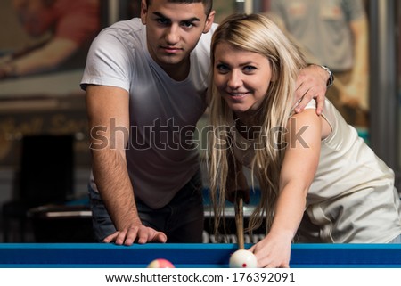 Couple In A Nightclub Playing Pool - Young Caucasian Woman Receiving Advice On Shooting Pool Ball While Playing Billiards