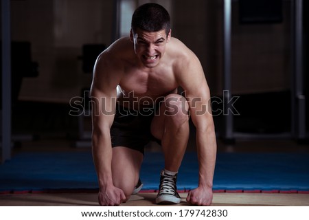 Survival Of The Fittest - Strong Muscular Men Without The Shirt Kneeling On The Floor - Almost Like Sprinter Starting Position