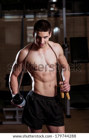 Health and Fitness - Handsome Muscular Man With Jumping Rope - Holding A Bottle Of Water In His Hand