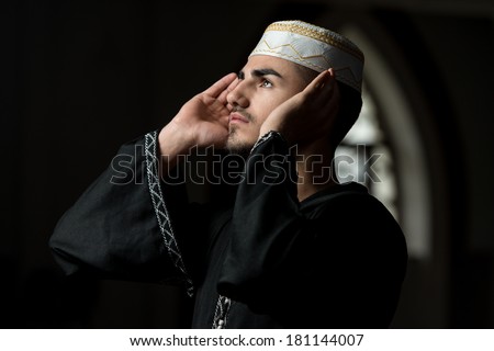 Muslim Man Is Praying In The Mosque Guy Making Traditional Prayer To God While Wearing A Traditional Cap Dishdasha Muslim Man Is Praying In The Mosque Guy Making Traditional Prayer To God While Wearing A Traditional Cap Dishdasha