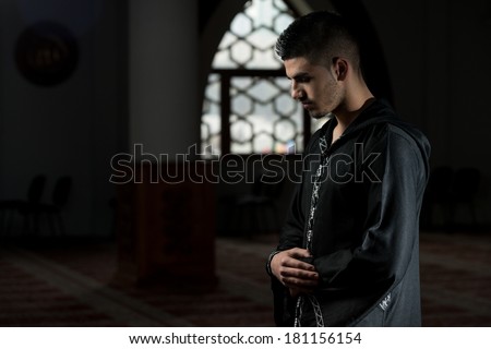 Humble Muslim Prayer - Man Making Traditional Prayer To God While Wearing A Traditional Cap Dishdasha