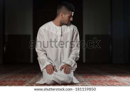 Muslim Man Is Praying In The Mosque - Guy Making Traditional Prayer To God While Wearing A Traditional Cap Dishdasha