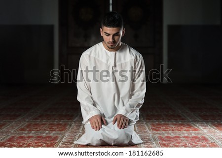 Muslim Praying In Mosque - Young Man Making Traditional Prayer To God While Wearing A Traditional Cap Dishdasha