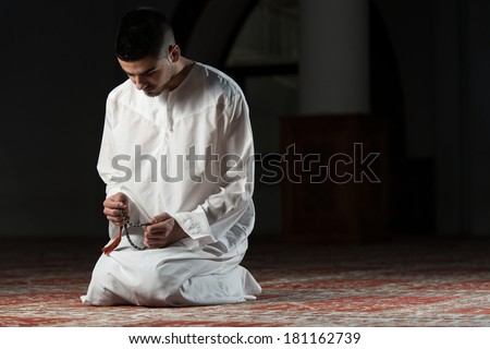 Enlightenment - Young Muslim Man Making Traditional Prayer To God While Wearing A Traditional Cap Dishdasha